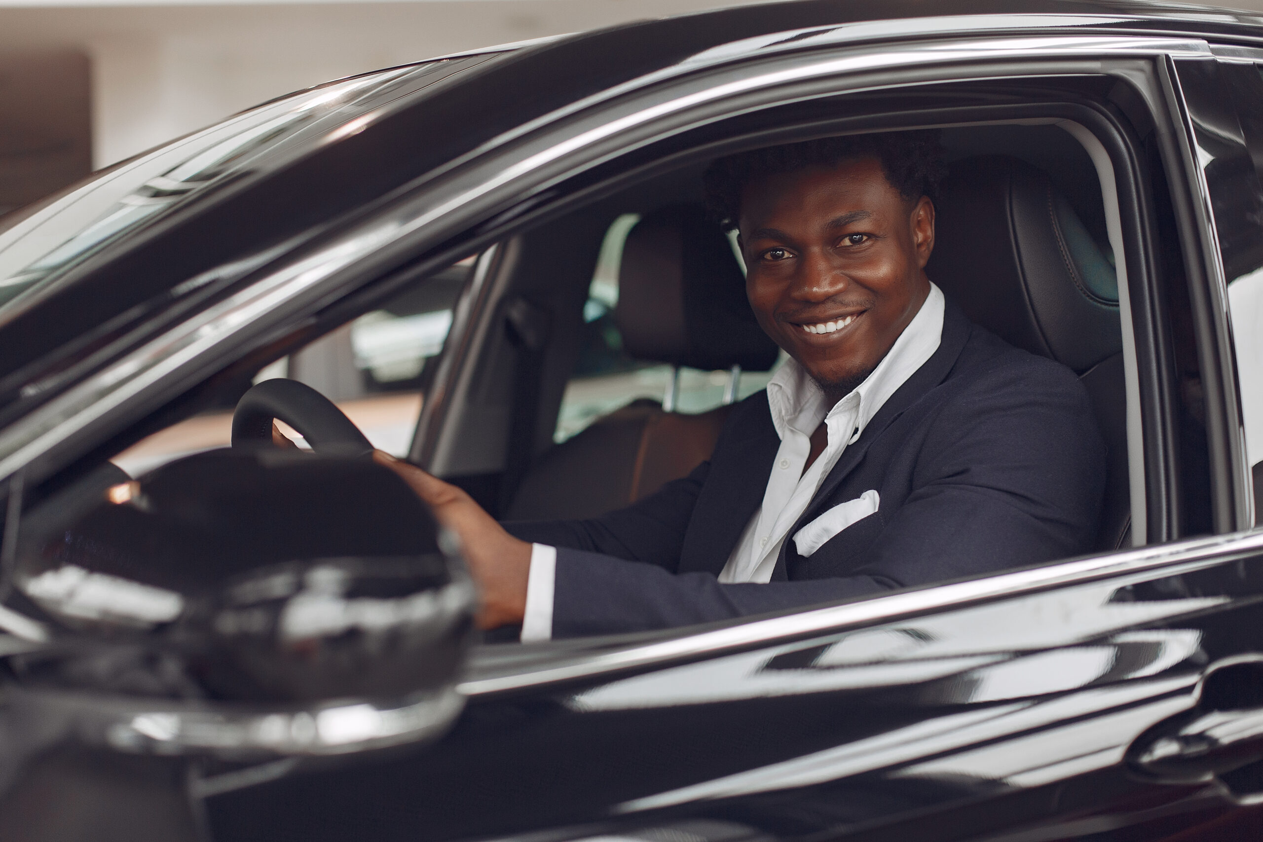 handsome and elegant black man in a car salon